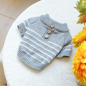 Detailed close-up of pet striped knit sweater with three wooden buttons and ribbed edges