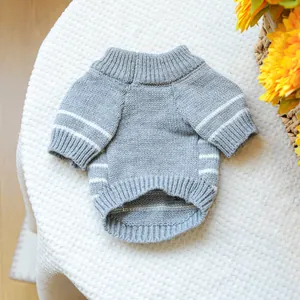 Detail of grey knitted pet sweater with white stripes on soft white texture background