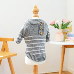 Close-up of pet knit sweater with grey and white stripes and vintage wooden buttons