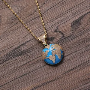 Close-up of a blue and gold globe pendant necklace with a twisted rope chain over wood