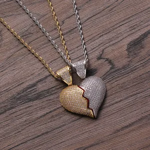 Macro di una collana con ciondolo a cuore spezzato in oro e argento con strass