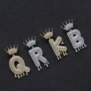 Makroaufnahme von Gold- und Silberschmuck-Anhängern mit Kronen und funkelnden Kristallen