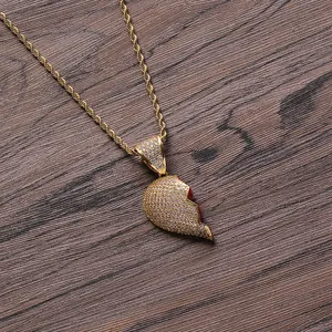 Collana con ciondolo a cuore hip hop placcata in oro e pietre pavé su fondo legno