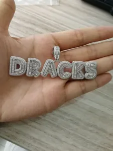 Macro shot of silver plated pendant with micro-pave zircons spelling DRACKS in hip hop style