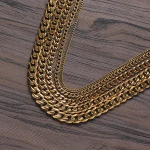 Macro detail of various widths gold-plated Cuban link chains on a wood background
