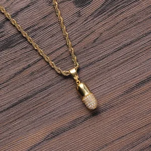 Detalle del colgante de cápsula dorada con pavé de circonitas en cadena de cuerda