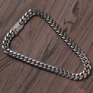 Detail of silver Cuban link chain with sparkling diamond-encrusted box clasp on wood