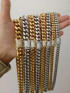 Primo piano di collane a catena cubana in oro e argento con chiusure in pavé di diamanti