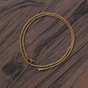 Macro detail of 2mm gold twisted rope chain with secure lobster clasp on wood
