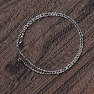 Detailed view of silver twist rope chain with secure lobster clasp on wood background