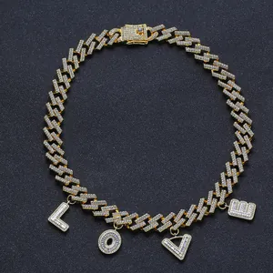 Detalle de cadena cubana dorada con colgantes de letras LOVE y circonitas
