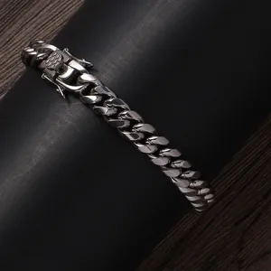Close-up of silver stainless steel Cuban link bracelet with engraved clasp detailing