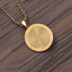 Collier à pendentif circulaire doré poli avec chaîne corde sur fond en bois sombre