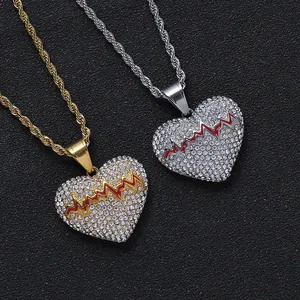 Nahaufnahme von goldener und silberner Herzhalskette mit roter EKG-Linie und Kordelkette