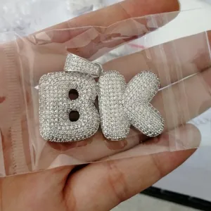 Detailed close-up of iced-out BK initial pendant with micro-paved cubic zirconia stones