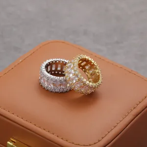 Bagues hip-hop serties de zircons carrés en or et argent sur un coffret en cuir