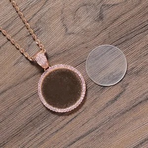 Runder Fotoanhänger mit rosa Zirkonia-Rand und goldener Kordelkette auf Holz