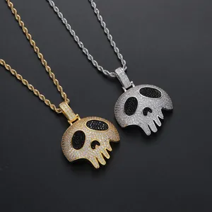 Détail de pendentifs crâne hip-hop incrustés de zircons sur chaînes torsadées or et argent