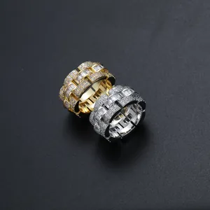 Macro di anelli hip hop iced-out color oro e argento con zirconi su sfondo nero
