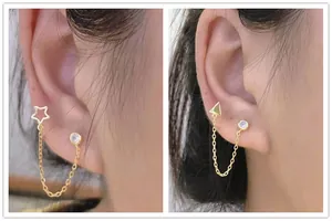Detail of s925 silver chain earrings with gold star and triangle charms with single zircons