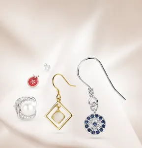 Detailed set of S925 silver earrings with pearls and zircon inlays on silk background