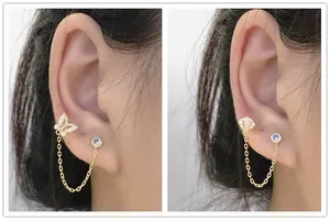 Macro view of S925 silver double piercing chain earrings with butterfly and shell design