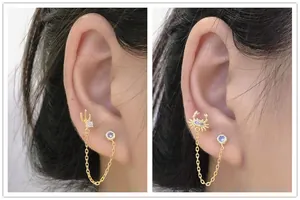 Detail of s925 silver double earring chain with cactus and crab zircon pendants