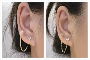 Detail of s925 silver double piercing chain earrings with star and purple stones