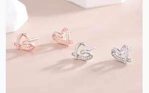 Detailed view of hollow heart stud earrings in rose gold and silver with cubic zirconia