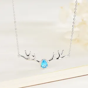 Collier bois de renne en argent S925 avec pierre bleue en forme de goutte sur un livre