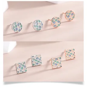 Detail of geometric s925 silver earrings with pastel enamel pattern and metallic frames
