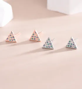 Macro detail of geometric mosaic triangle earrings in silver and rose gold finishes