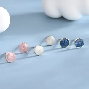 Three pairs of irregular geometric enamel stud earrings in pink, white and dark blue