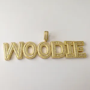 Detailed close-up of golden hip hop pendant with WOODIE lettering and micro-pave zircons