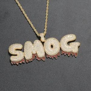 Dettaglio del ciondolo SMOG hip hop con zirconi micro-pave e goccia di pietra rossa