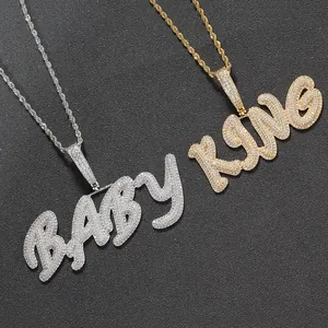 Detail of silver BABY and golden KING hip-hop pendants with micro-paved zircons