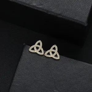 Golden Trinity Knot earrings with pavé zircons on black textured jewelry box