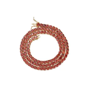 Golden tennis chain with 4mm round red zircons and secure lobster clasp on white backdrop