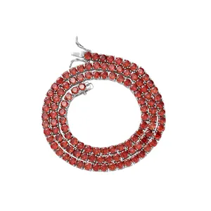 Macro detail of 4mm red zircon tennis chain with secure clasp and silver metal base