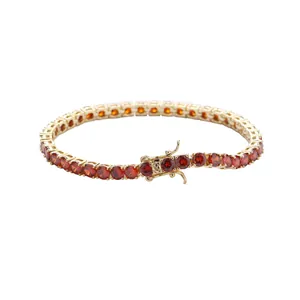 Detail of 4mm gold-plated tennis bracelet featuring red cubic zirconia and double safety clasp