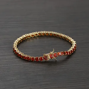 Gold-plated 4mm tennis bracelet with round red cubic zirconia on a wood background