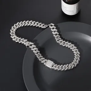 Macro shot of silver Cuban link necklace with pavé zircons on black display tray