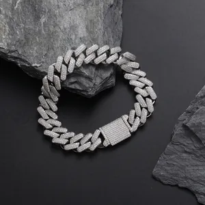 Detail of 13mm iced out Cuban link bracelet with micro-paved zircons on a rock surface