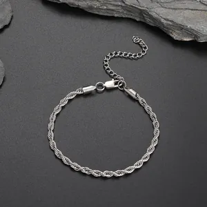 Silver rope chain anklet with lobster clasp and extension on a dark stone background