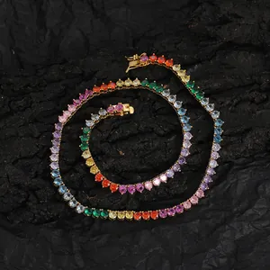 Detail of multi-color tennis chain with rainbow zircons and gold-plated clasp on black rock