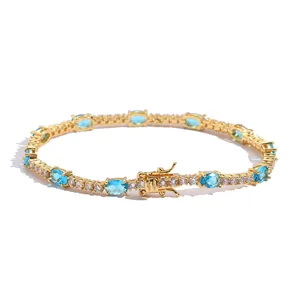 Golden tennis bracelet featuring oval blue gemstones and shimmering zircon accents