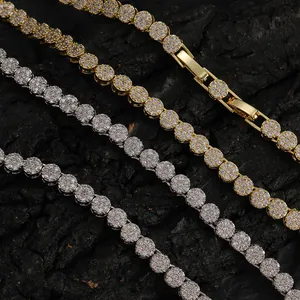 Gold and silver 5mm tennis necklaces with zircons on dark stone background