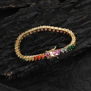 Colorful gemstone tennis bracelet with 4mm cubic zirconia on gold base over dark rock