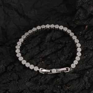 Macro shot of a 5mm silver tennis chain with round zircon stones on dark stone background