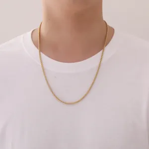 Close-up of 3mm golden stainless steel wheat chain worn by a male model over a white shirt